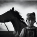 3. díj, Sport kategória, egyedi - Lengyelország, Yours Gallery/Focus Photo und Presse Agentur
Fiatal lovas áll lova mellett a mongóliai Naadam fesztiválon júliusban. A fesztivál eredete egészen a 12. századig, Dzsingisz kán koráig vezethető vissza, s programjában az ország legnépszerűbb sportjai szerepelnek: lovaglás, íjászat és birkózás. A füves vidéken rendezett különféle versenyekre mintegy ezer lovat választanak ki. Csekély súlyuk miatt előnyben részesítik a gyereklovasokat. Emellett úgy tartják, hogy ha a lovat egy gyerek üli meg, akkor a verseny egészen biztosan a paripa ügyességét fogja mérni és nem a lovasét. Az öt nyertes ló nevét versekben és dalokban örökítik meg. A legjobb lovas elnyeri a tumny ekh avagy “tízezrek vezetője” címet.